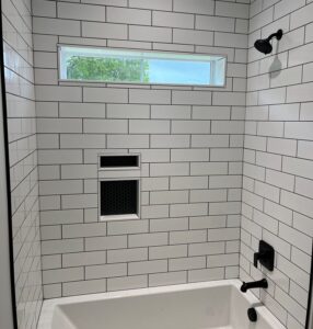 This image shows a bathtub with white tiling.