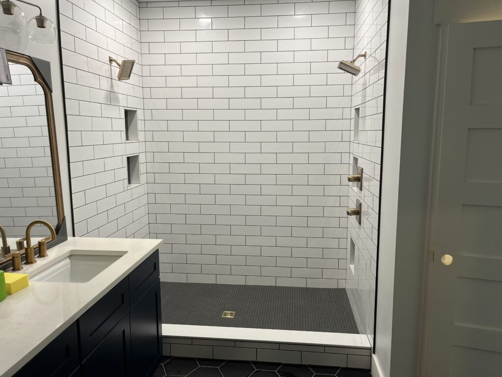 This image features a shower with white, square tiling. 